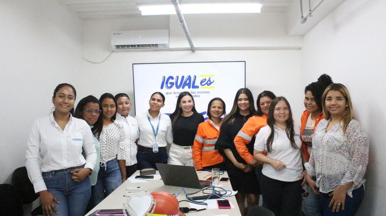 Trabajadoras de una empresa posan juntas frente a una pantalla con el mensaje «IGUALes, que tengamos las mismas oportunidades».